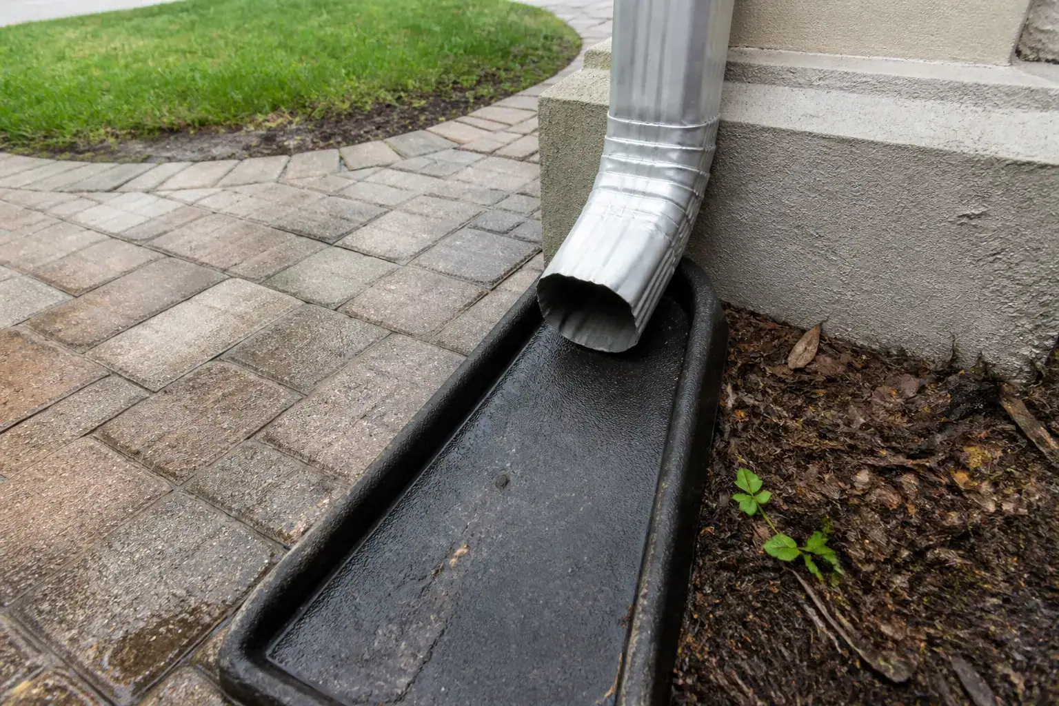 Gutter installation in Lakeland, FL: aluminum downspout after rain