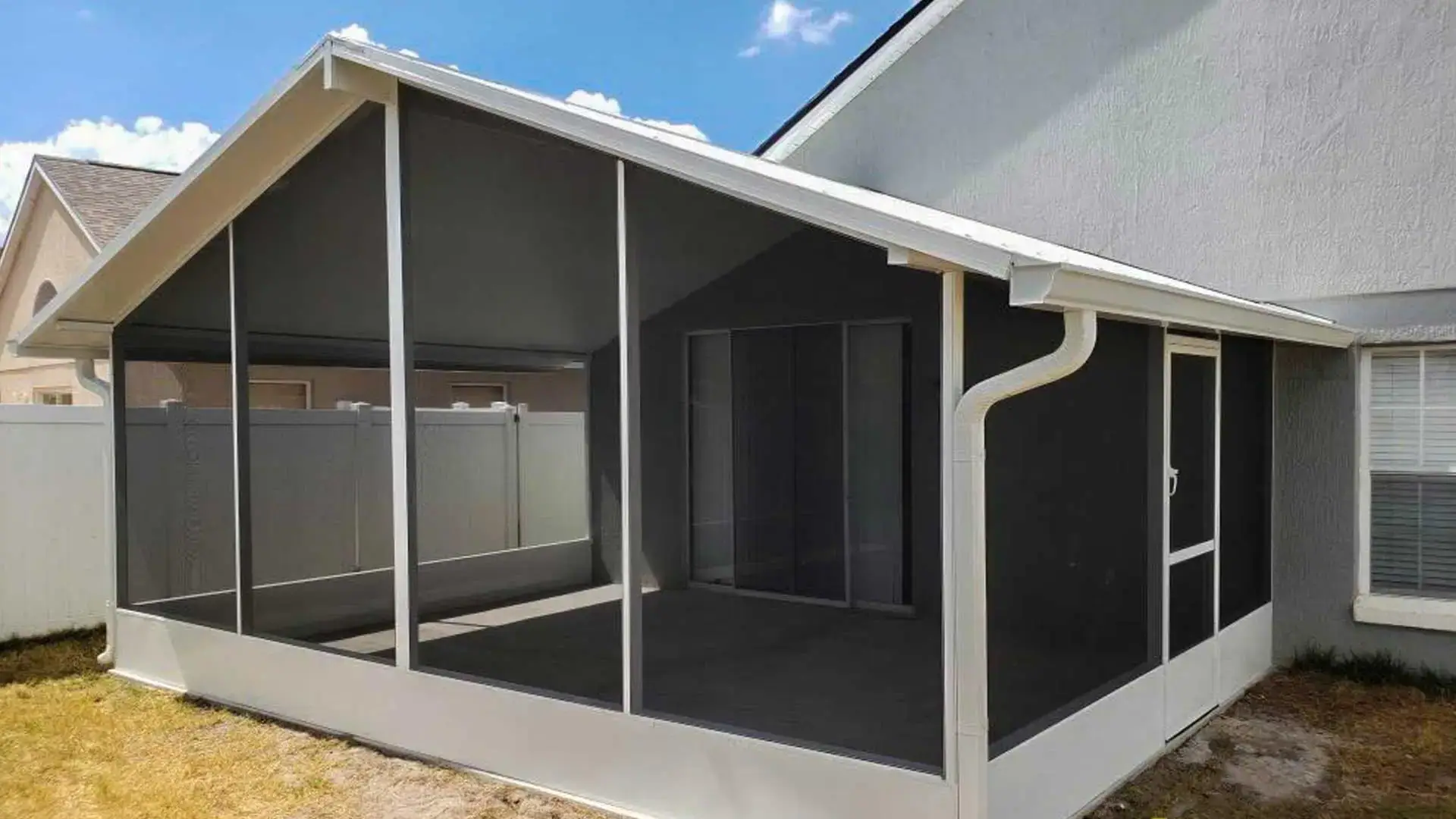 Screened patio enclosure with white aluminum frame attached to a home