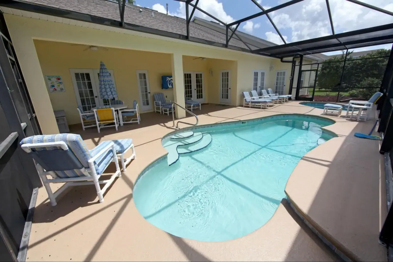 Screened pool enclosure and covered patio with outdoor seating at a Florida home