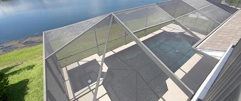 Overhead view of a screened pool cage covering a Florida backyard pool